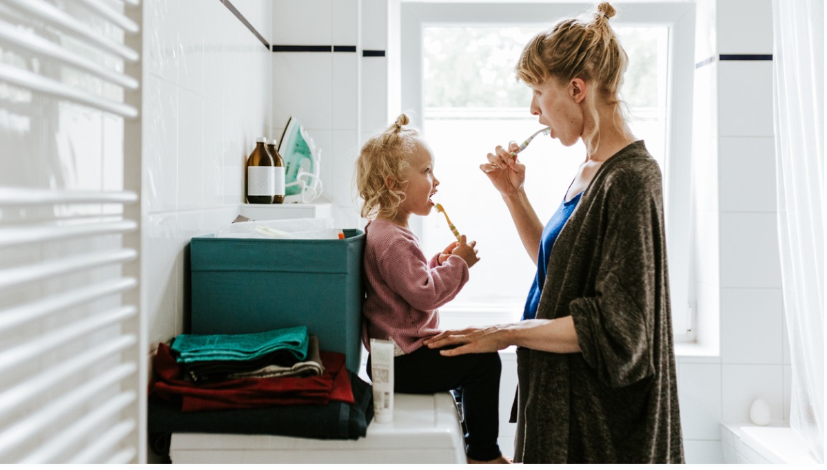 young-mother-with-a-child-brushing-teeth-in-the-morning