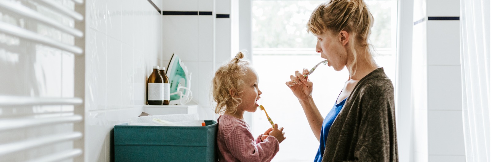 "young-mother-with-a-child-brushing-teeth-in-the-morning