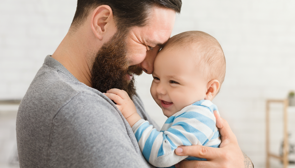 Dad holding smiling baby