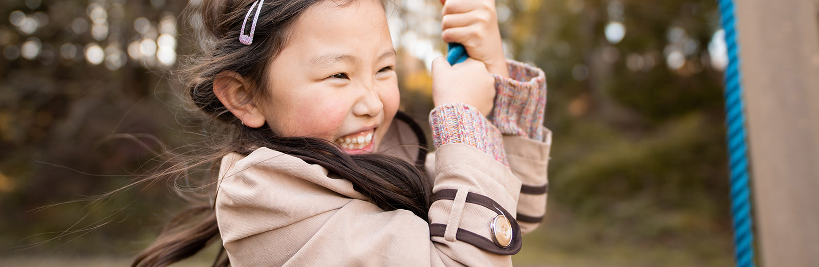 Smiling child on swing - hero size