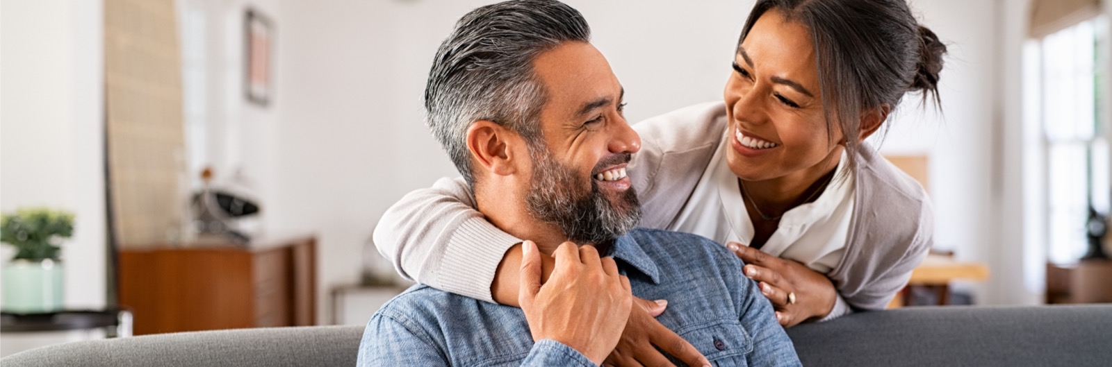 Mature multi-ethnic couple looking at each other and smiling. 